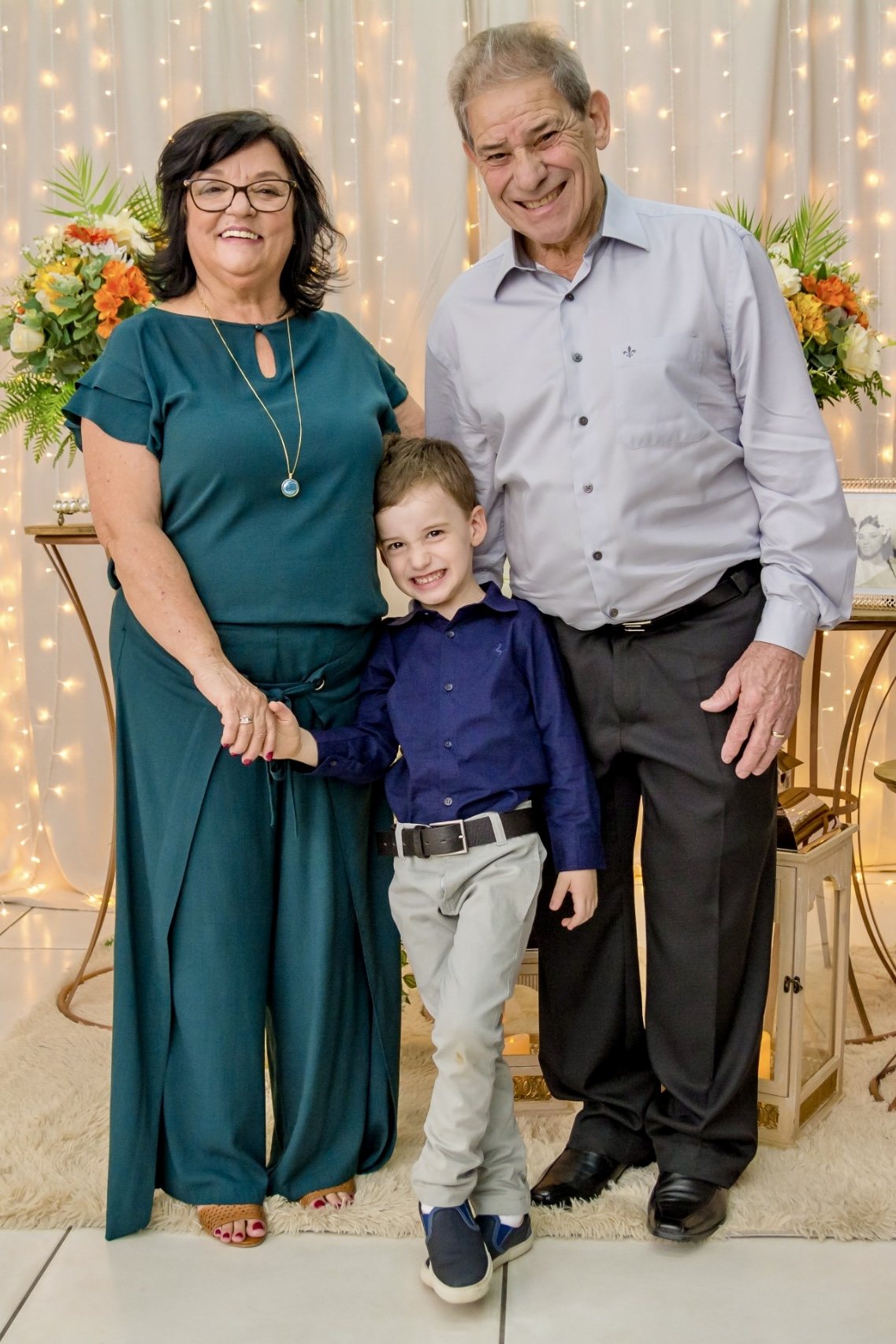 Silvio sorrindo ao lado da esposa e do neto